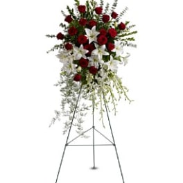 Standing floral spray with red roses and white lilies on an easel