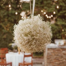 Hanging white baby's breath floral ball at an outdoor event