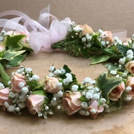 Floral wreath of pale pink roses and white baby's breath with a sheer ribbon
