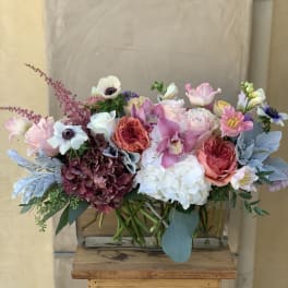 Mixed bouquet of pink, white, and purple flowers in a glass vase