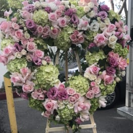 Heart-shaped floral wreath with pink and purple roses and green hydrangeas