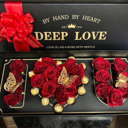 Red roses and gold-wrapped chocolates arranged in a gift box