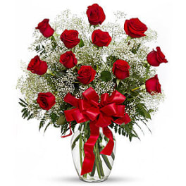 Red roses in a clear glass vase with a red ribbon bow