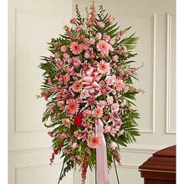Standing spray of pink flowers with a ribbon on an easel