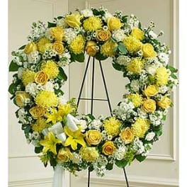 Yellow and white floral wreath on a black stand