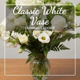 White floral arrangement in a clear glass vase with overlaid text