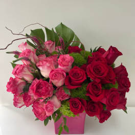 Pink and red rose arrangement in a pink vase