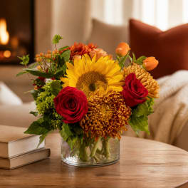 Sunflower and red rose bouquet in a clear glass vase