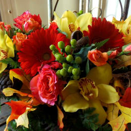 Bouquet of red gerbera daisies, pink roses, and yellow orchids
