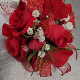 Bouquet of red roses with small white filler flowers and red mesh ribbon