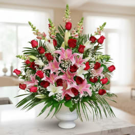 Red roses and pink lilies arranged in a white vase