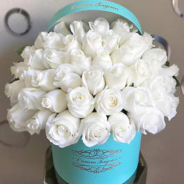 Bouquet of white roses in a turquoise hatbox