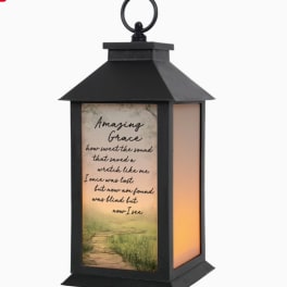 Black lantern with a printed "Amazing Grace" panel and warm light inside