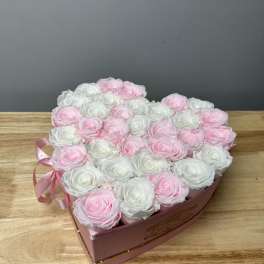 Heart-shaped box of pink and white roses with a ribbon bow
