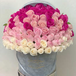Round hatbox packed with ombre roses from fuchsia to blush pink to ivory