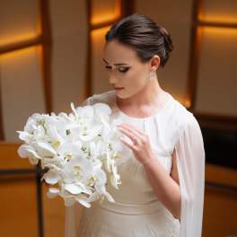 Bride holding a large white orchid bouquet