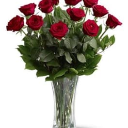 Red roses arranged in a clear glass vase