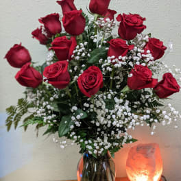 Red roses with white baby's breath in a glass vase