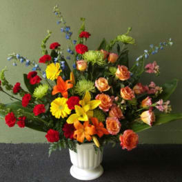 Colorful mixed flower arrangement in a white vase