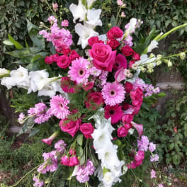 Large standing floral spray with pink roses, gerbera daisies, and white gladiolus