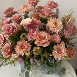 Peach and pink roses with chrysanthemums in a glass vase