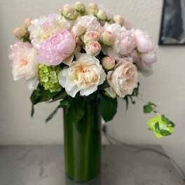 Pink and white bouquet in a tall green vase