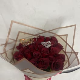 Bouquet of red roses wrapped in clear paper with a pink ribbon