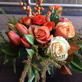 Orange and cream rose bouquet with tulips and berry branches
