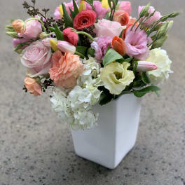 Mixed pastel bouquet in a white square vase