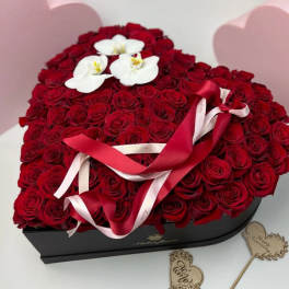 Heart-shaped box filled with red roses and white orchids