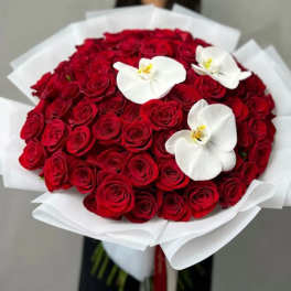 Bouquet of red roses with white orchid blooms wrapped in white paper
