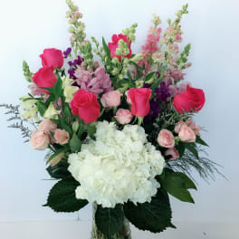 Mixed pink and white flowers arranged in a glass vase