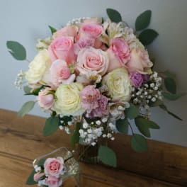 Pink and cream rose bouquet in a glass vase with a small matching posy