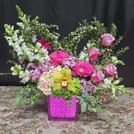 Pink and white floral arrangement in a bright magenta vase