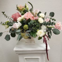 Mixed pink and white flower arrangement in a white vase