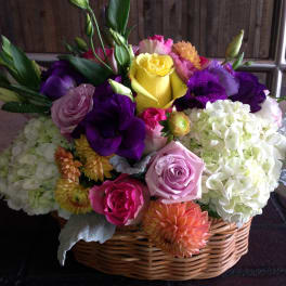 Colorful mixed flower arrangement in a wicker basket