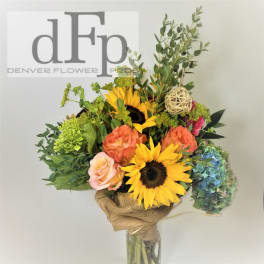 Bouquet with sunflowers, roses, hydrangea, and greenery in a glass vase
