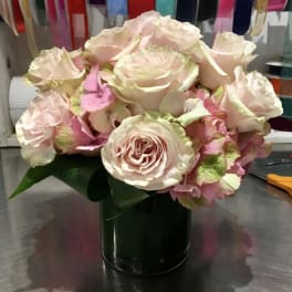 Blush roses arranged in a dark green vase