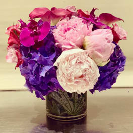 Pink and purple floral arrangement in a glass vase