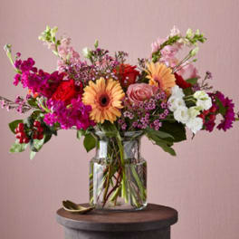 Mixed bouquet in a clear glass vase with pink, red, and white flowers