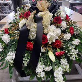 Large funeral spray with red and white flowers and black ribbon