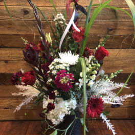 Tall mixed bouquet with red and white flowers in a black vase