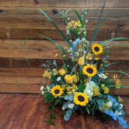 Tall floral arrangement with sunflowers and yellow roses