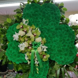 Green floral standing tribute with white orchids and roses