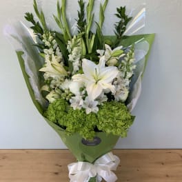 White lily bouquet with green hydrangea and a white ribbon