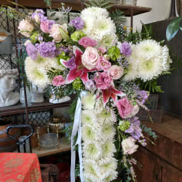 Large cross-shaped floral tribute with white chrysanthemums and pink roses