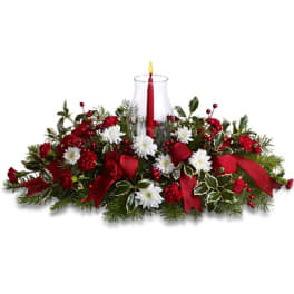 Christmas centerpiece with red candle, white flowers, and ribbon