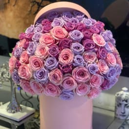 Round bouquet of pink and lavender roses in a pink hat box