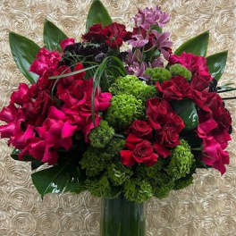 Bouquet of red and pink flowers in a tall glass vase
