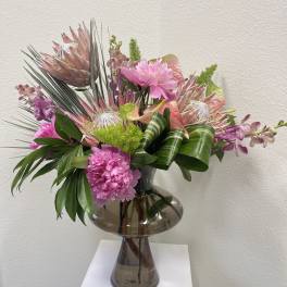 Pink tropical bouquet in a smoked glass vase